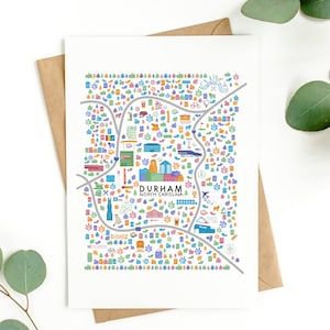 May include: A colorful illustrated map of Durham, North Carolina. The map features various landmarks and points of interest, including buildings, parks, and businesses. The map is printed on white cardstock and has a brown envelope.