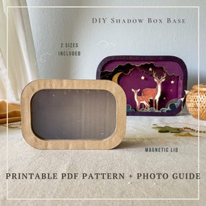 May include: A DIY shadow box base with a magnetic lid. The image shows two sizes included. One is a rectangular frame with a clear window. The other is a purple shadow box with a deer scene. The text says "PRINTABLE PDF PATTERN + PHOTO GUIDE."