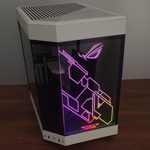 Pode incluir: Uma caixa de computador branca e preta com um painel lateral transparente. O painel exibe um gráfico iluminado colorido e o texto "REPUBLIC OF GAMERS". A caixa tem um design angular único.