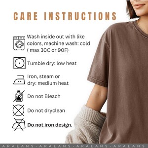 May include: A brown t-shirt with care instructions text: Wash inside out with like colors, machine wash cold max 90F, tumble dry low heat, iron steam or dry medium heat, do not bleach, do not dryclean, and do not iron design.