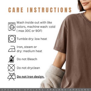 May include: A brown t-shirt with care instructions printed in a light brown font. The instructions include washing, drying, and ironing guidelines. The text reads "Wash inside out with like colors, machine wash: cold (max 30C or 90F)".