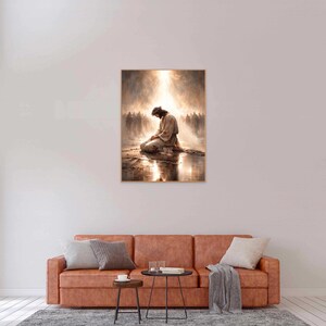 May include: A framed art print depicts a figure kneeling in prayer, bathed in a radiant light. The artwork features a warm color palette with a soft, ethereal quality, suggesting a spiritual theme. A crowd of figures is in the background.