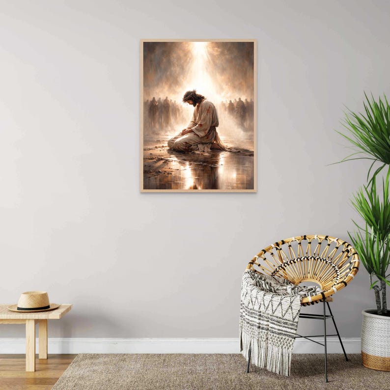 May include: A framed print depicts a figure kneeling in prayer, bathed in a heavenly light. The artwork features warm, earthy tones and a reflective surface, with a crowd of figures in the background. The frame is a light wood color.