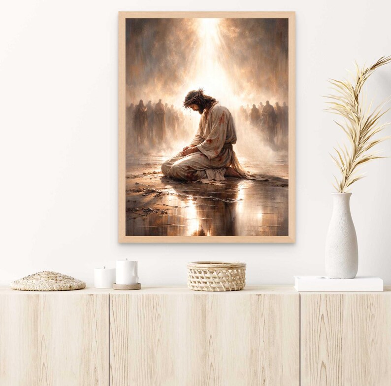 May include: A framed print depicts a religious scene with a figure kneeling in prayer, bathed in golden light. The figure wears a crown of thorns and a robe. A crowd of figures is in the background. The artwork is in a wooden frame.