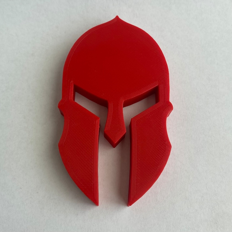May include: A red plastic Spartan helmet, a popular symbol of strength and courage.
