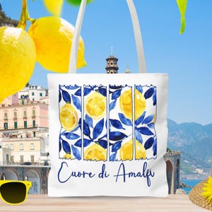 May include: White tote bag with a blue and yellow lemon design and the text "Cuore di Amalfi".