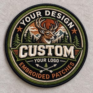 May include: A circular embroidered patch featuring a central deer head illustration against a mountain and forest backdrop. The text reads YOUR DESIGN, CUSTOM, YOUR LOGO, and EMBROIDERED PATCHES. The design includes two stars and crossed arrows.