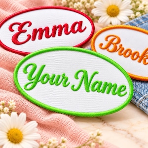 May include: Three oval-shaped embroidered patches with white fabric centers. One patch features the red text Emma, one has orange text reading Brook, and the third displays green text reading Your Name, each with a matching colored border.