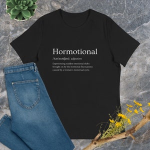 Könnte beinhalten: Schwarzes T-Shirt mit weißem Text, der lautet: "Hormotional /hɔrmoufənl/ Adjektiv Erleben von plötzlichen emotionalen Veränderungen, die durch hormonelle Schwankungen verursacht werden, die durch den Menstruationszyklus einer Frau verursacht werden."