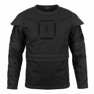 May include: A black long-sleeve shirt featuring a crew neckline, reinforced shoulder panels with horizontal stitching, and rectangular hook-and-loop patches on the chest and upper sleeves. The lower sleeves have vertical stitched detailing.