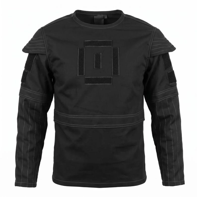 May include: A black long-sleeve shirt featuring a crew neckline, reinforced shoulder panels with horizontal stitching, and rectangular hook-and-loop patches on the chest and upper sleeves. The lower sleeves have vertical stitched detailing.