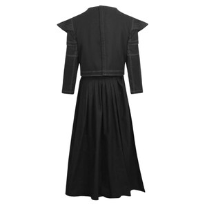 May include: A black two-piece outfit consisting of a cropped jacket and a long, pleated skirt. The jacket features structured, pointed shoulders, long sleeves, and prominent white contrast stitching along the seams and edges of the garment.