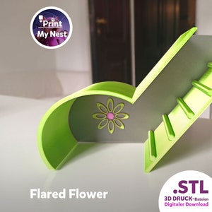 May include: A 3D-printed, lime green and grey decorative object with a flared flower design. The object features a flower with a pink centre. The text "Flared Flower" is at the bottom. The object is likely a decorative item or a component for a larger design.