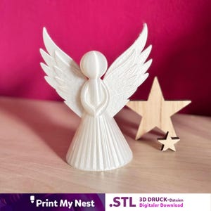 May include: A white 3D-printed angel figurine with outstretched wings, standing next to a wooden star. The angel has a flowing gown and detailed wings. The background is a vibrant pink.