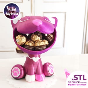 Op de afbeelding: Een magenta katvormige container gevuld met goud verpakte chocolaatjes. De container heeft een lachend gezicht en een witte hartvormige kraag. De poten hebben roze pootafdrukken. De tekst ".STL 3D DRUCK-Dateien Digitaler Download" is inbegrepen.