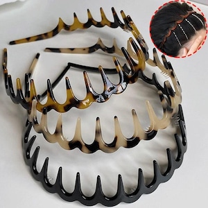 Op de afbeelding: Een verzameling haarbanden in verschillende kleuren en patronen. De haarbanden hebben een kamachtig ontwerp met gebogen tanden. De kleuren zijn zwart, schildpad en een lichter bruin schildpadpatroon. De haarbanden worden op een witte ondergrond getoond.