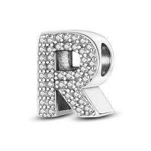 K&ouml;nnte beinhalten: Ein silberner Anh&auml;nger in Form des Buchstabens "R". Der Anh&auml;nger ist mit kleinen, klaren Kristallen besetzt, die einen funkelnden Effekt erzeugen. Das Design ist detailliert und dreidimensional, mit poliertem Finish.