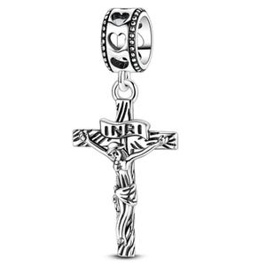 K&ouml;nnte beinhalten: Ein silberfarbener Charm-Anh&auml;nger mit einem Kreuzigungsdesign. Der Anh&auml;nger zeigt Jesus am Kreuz, mit den Buchstaben INRI auf einem Banner. Der obere Teil des Anh&auml;ngers hat einen Ring mit herzf&ouml;rmigen Ausschnitten.