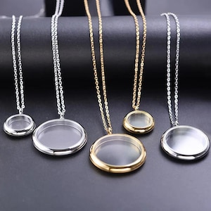 May include: Five necklaces with round, clear lockets. The chains and locket frames are silver and gold. The lockets are empty, ready to be filled with small keepsakes. The background is a dark, solid color.