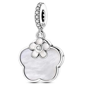 K&ouml;nnte beinhalten: Ein silberner Charm mit Blumenmuster. Der Charm hat eine gro&szlig;e, f&uuml;nfbl&auml;ttrige Bl&uuml;tenform mit einem Perlmuttzentrum. Eine kleinere Blume mit einem klaren Stein sitzt oben. Die obere Schlaufe ist mit klaren Steinen besetzt.