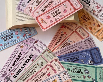 May include: A collection of colorful, ticket-shaped bookmarks with various themes like "Spicy Romance," "Sci-Fi Reader," and "Cozy Girl." Each bookmark features decorative illustrations and the text "Lifetime membership to the Book Club."