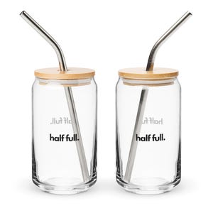May include: Two clear glass tumblers with bamboo lids and stainless steel straws. Each tumbler has the text "half full." printed on the side.