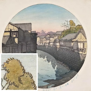 May include: A Japanese woodblock print depicting a canal scene with traditional houses lining the banks. The print is in shades of blue, gray, and brown, with a hint of pink in the sky. The text at the bottom reads "江戸の橋 二番橋".