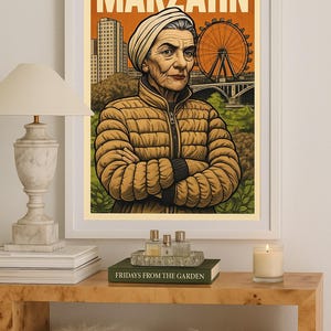 Könnte beinhalten: Gerahmter Kunstdruck mit dem Wort "MARZAHN" oben, der eine Frau in einer beigen Jacke vor einem Hintergrund mit Riesenrad, Gebäuden und einer Brücke zeigt. Der Druck wird auf einem Holztisch präsentiert.