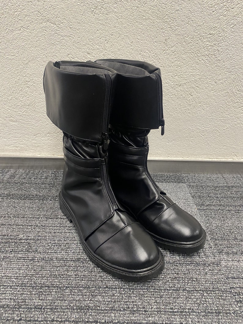 May include: A pair of black leather boots with a zipper up the side and a fold-over cuff at the top.