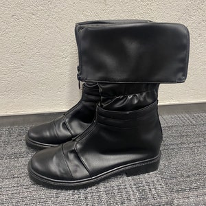 May include: Black leather boots with a fold-over cuff and a zipper up the front. The boots have a chunky sole.