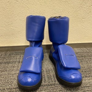 May include: A pair of blue leather boots with a zipper on the back and a flap pocket on the side.