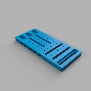 May include: A blue plastic tool with multiple holes and slots. The tool is designed for holding and organizing small objects.