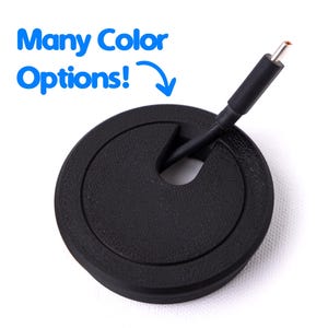 May include: A black round cable grommet with a slot for wires. A black cable is inserted through the slot. The text "Many Color Options!" is in blue above the grommet.