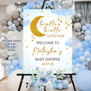 May include: Blue and gold baby shower welcome sign with a crescent moon, stars, and clouds. The sign says "twinkle twinkle little star" and "Welcome to Natasha's Baby Shower 04-07-25".