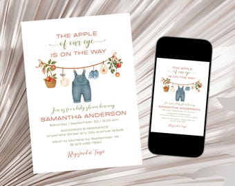 May include: Baby shower invitation with the text "The apple of our eye is on the way." The invitation features a watercolor illustration of baby clothes and a mobile phone displaying the same design.