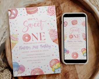 May include: A birthday invitation with the text "SHE'S A Sweet ONE" and illustrations of sweets. A smartphone displays the same invitation. The invitation is on a wooden tray.