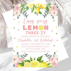 May include: A lemon-themed birthday invitation featuring pink flowers, green leaves, and yellow lemons. The text reads "Easy peezy LEMON THREE-ZY. Please join us to celebrate Elizabeth's 3rd Birthday! Saturday | November 24th | 3PM. Event Center Anywhere Street. Any City Avenue 12345. RSVP to Michelle at 123-456-7890."