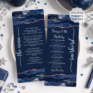 以下が含まれることがあります： ネイビーブルーのメニューとプログラムカードセット、ゴールドのアクセント付き。メニューには前菜、メインコース、デザート、ドリンクが記載されています。プログラムカードにはイベントスケジュールが記載されています。カードのサイズは9.9cm x 21cmです。