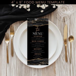 May include: A black and gold food menu template, 4 x 9 inches, with a list of menu items. The menu is on a white plate with gold silverware. The menu includes starters, main courses, desserts, and drinks.