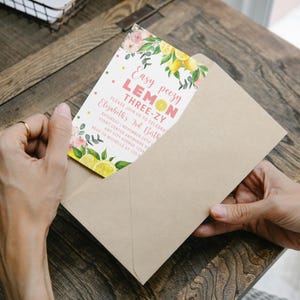 May include: A lemon-themed birthday invitation with pink and yellow watercolour illustrations of lemons, flowers, and confetti. The text reads "Easy peezy LEMON THREE-ZY Elizabeth's 3rd Birthday" with details for the event.