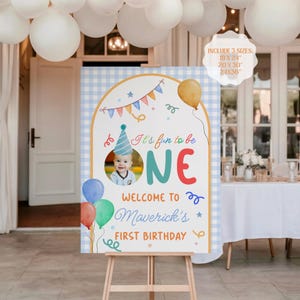 Może przedstawiać: Spersonalizowany znak powitalny na urodziny na sztaludze. Znak zawiera zdjęcie dziecka, słowa "It's fun to be ONE" i "Welcome to Maverick's First Birthday". Zawiera rozmiary 45,7x61cm, 50,8x76,2cm i 61x91,4cm.