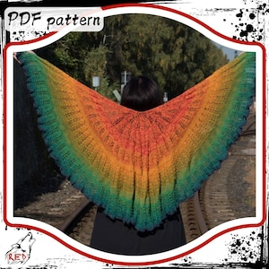 May include: A rainbow colored crochet shawl with a lacy pattern. The shawl is draped over the shoulders of a person standing on a train track.