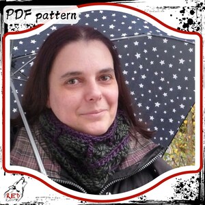 Könnte beinhalten: Eine Frau trägt eine schwarze Jacke, ein kariertes Hemd und einen dunkelgrünen und violetten Häkel-Halswärmer. Sie hält einen blauen Regenschirm mit weißen Sternen darauf. Der Text "PDF pattern" ist in der oberen linken Ecke des Bildes sichtbar.