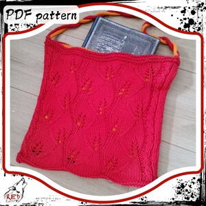 Könnte beinhalten: Eine rote gestrickte Tragetasche mit einem Blatt-Muster und orangefarbenen Henkeln. Die Tasche ist groß genug, um ein Buch zu verstauen. Der Text "PDF pattern" ist in der oberen linken Ecke des Bildes sichtbar.