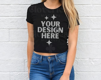 May include: A black cropped t-shirt with the text "YOUR DESIGN HERE" in gray. The shirt is being worn by a person with long blonde hair.