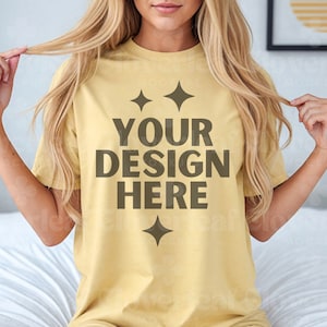 Może przedstawiać: Ż&oacute;łta koszulka z napisem "YOUR DESIGN HERE" w brązowych literach. Koszulka ma dwie małe brązowe gwiazdki nad napisem i jedną pod napisem.