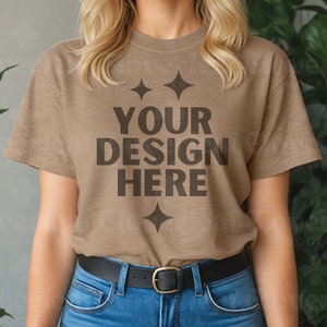 Puede incluir: Una camiseta marrón de manga corta y cuello redondo. La camiseta tiene el texto "YOUR DESIGN HERE" impreso en negro en la parte delantera.