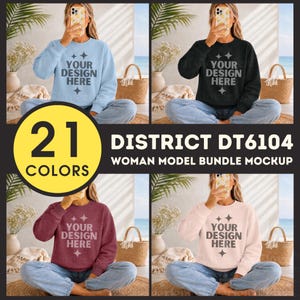 May include: A bundle of four District DT6104 crewneck sweatshirts in light blue, black, maroon, and light pink. Each sweatshirt features the text YOUR DESIGN HERE with star accents. The garments are shown on a model wearing blue jeans.