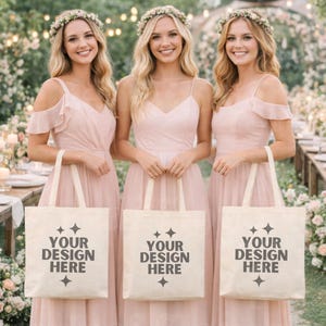 Puede incluir: Tres mujeres con vestidos rosas y coronas de flores, cada una sosteniendo una bolsa de mano crema. Las bolsas tienen el texto "YOUR DESIGN HERE" en negro. El fondo muestra un entorno exterior borroso.