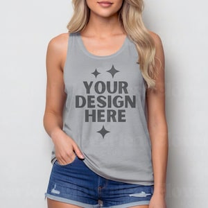Puede incluir: Un top de tirantes gris con el texto "YOUR DESIGN HERE" en negro. El top tiene un escote redondo y un corte holgado.